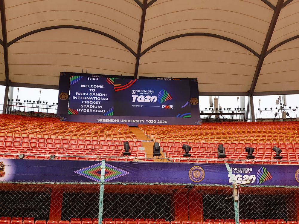 LED screen showing live event clock and TG20 branding under the stadium canopy